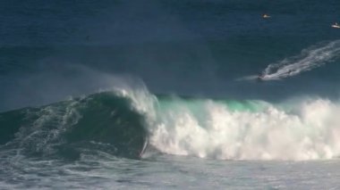 Büyük dalgalarda sörf yapan sörfçü Hawaii 'nin Maui adasının kuzey kıyısında Jaws' ı kırdı.
