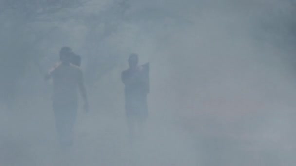 Twee Mensen Die Pakjes Uit Met Rook Gevulde Savanne Dragen — Stockvideo