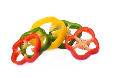 Kırmızı biber dilimlenmiş sarı, yeşil, kırmızı, beyaz arka planda izole edilmiş.