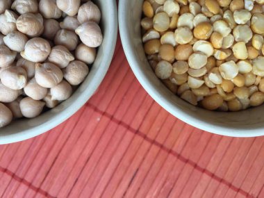 Kırmızı arka planda baklagiller, bezelyeler ve nohutlar.