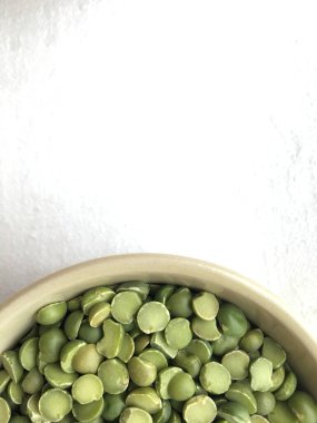 Beyaz bir yüzeyde kuru yeşil bezelyeli bir tabak..