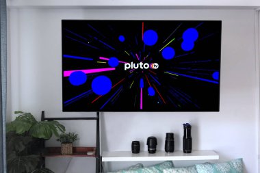 Merhaba, ABD - 21 Mayıs 2020: Pluto TV kablolu TV servis sağlayıcısı logosu ev eğlence duvarına monte edilmiş grafik arka plan.