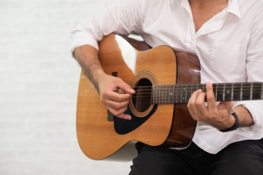 Beyaz arkaplanda gitar çalan adam