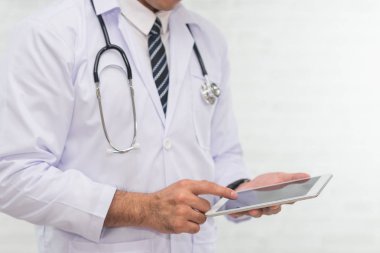 Doktor beyaz arka plan üzerinde dijital tablet kullanma