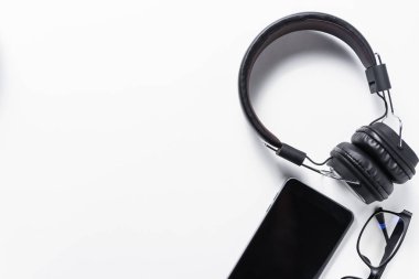 kulaklık ve beyaz arka plan, müzik konsepti üstünde hareket eden telefon düz lay