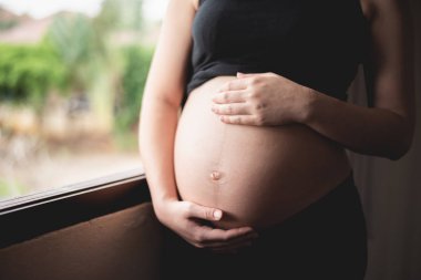 Sevimli bir hamile göbeğini kapat.