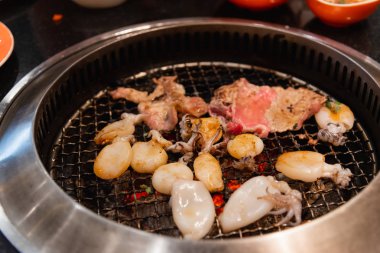 Barbekü veya Japon tarzı yakiniku için ızgara üzerinde ham sığır eti ve domuz eti dilim