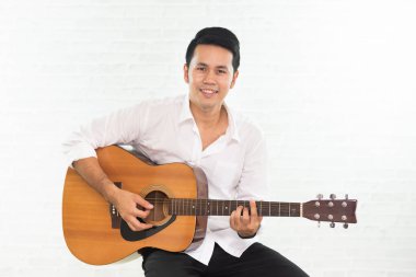 Beyaz arkaplanda gitar çalan adam