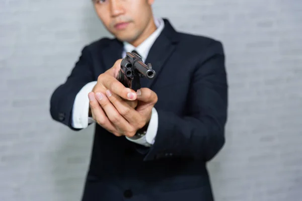 Geschäftsmann Mit Waffe Auf Grauem Hintergrund — Stockfoto