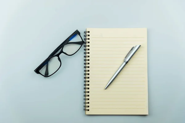 Σημειωματάριο, πένα και γυαλιά σε γκρι φόντο — Φωτογραφία Αρχείου