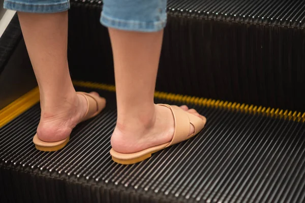 close up of feet girl standing on the escalator