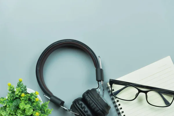 Notebook szemüveg és fülhallgató szürke alapon — Stock Fotó