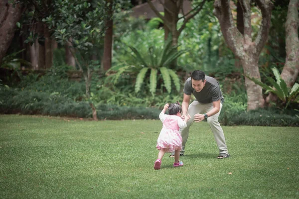 cute baby playing with father in the garden