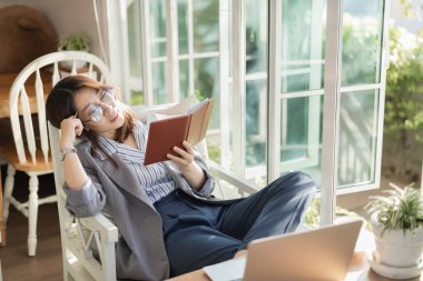 Çalışan kadınlar not defteri okuyor ve kafede çalışıyor.