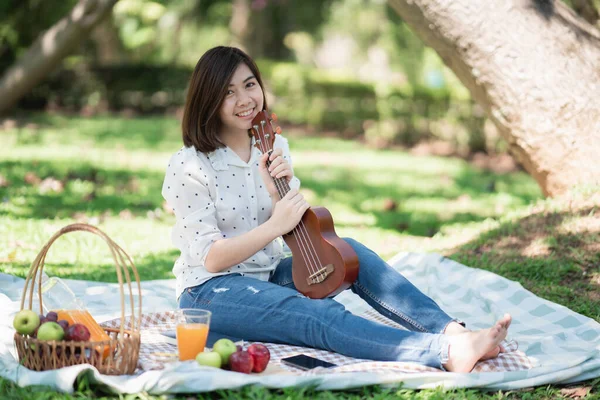 Mulheres Asiáticas Sentadas Grama Durante Piquenique Escrever Música Parque — Fotografia de Stock