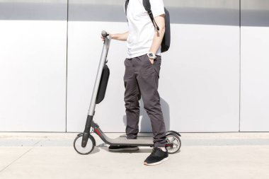 Genç adam caddenin üzerinde elektrikli scooter üzerinde rahat kıyafet