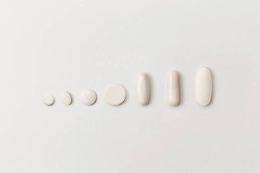 Beyaz arka planda çeşitli şekillerde tıbbi haplar.