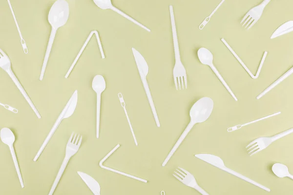 Food plastic packaging on green background. Concept of Recycling plastic and ecology. Plastic waste. Collection of various cutlery. Flat lay, top view