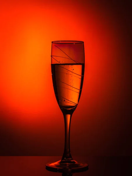 一杯香槟 在橙色的背景上 边缘有一个漂亮的小饰物 装饰聚会或假日的想法 — 图库照片