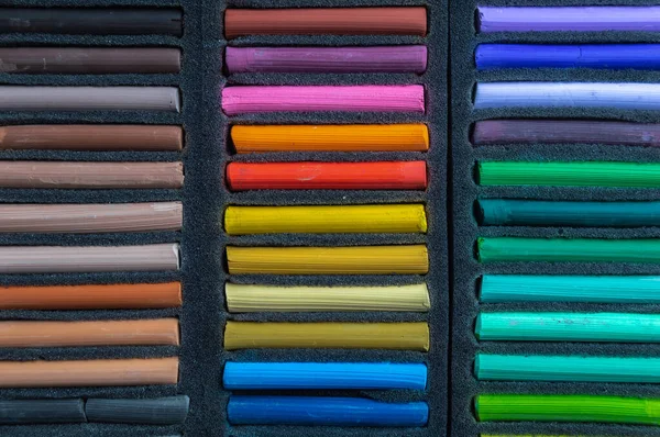 Crayons for drawing in a box on a white background. Dry pastels for artists.
