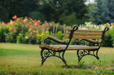 Çiçekli bir yaz bahçesindeki bankta. Seçici odak