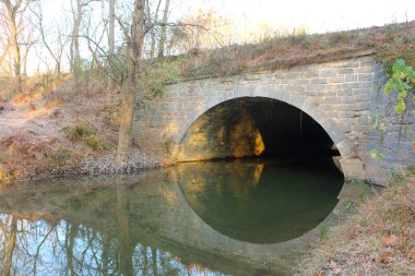 Antik bir kemerli nehir köprüsü Yansımalı gün doğumuyla