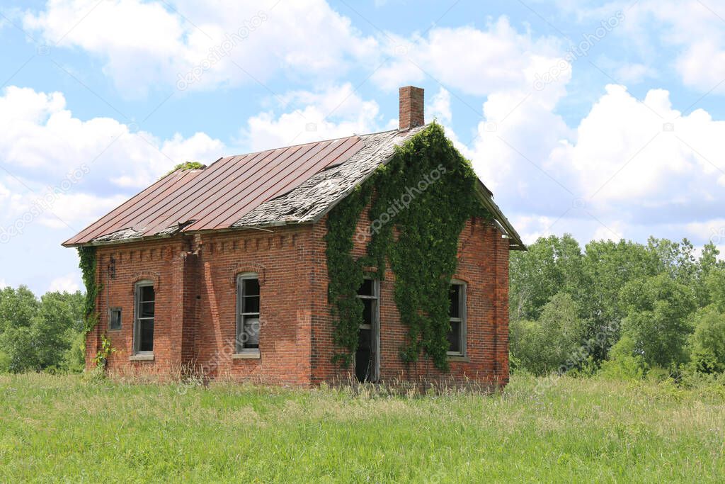 an abandoned overgrown brick old school house building