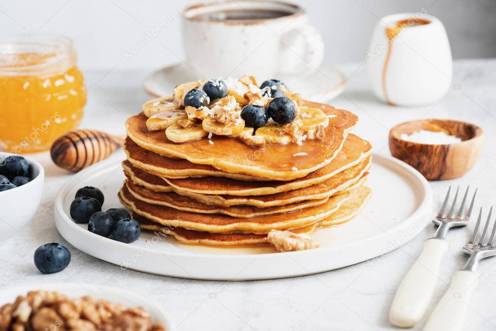 Pancakes with nuts, honey and fruits for breakfast