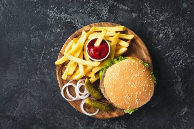 Burger, hamburger veya çizburger patates kızartması, turşu ve soğan ile servis