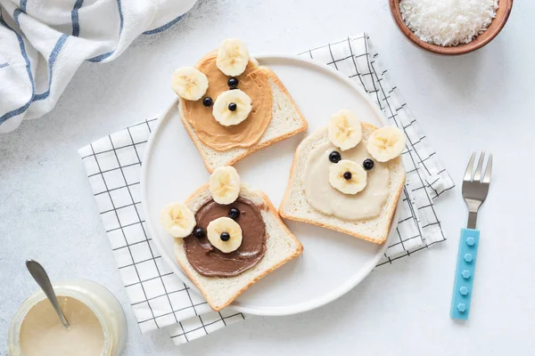 Torradas de café da manhã com manteiga de noz e banana com cara de animal engraçado bonito. Alimentos para crianças — Fotografia de Stock