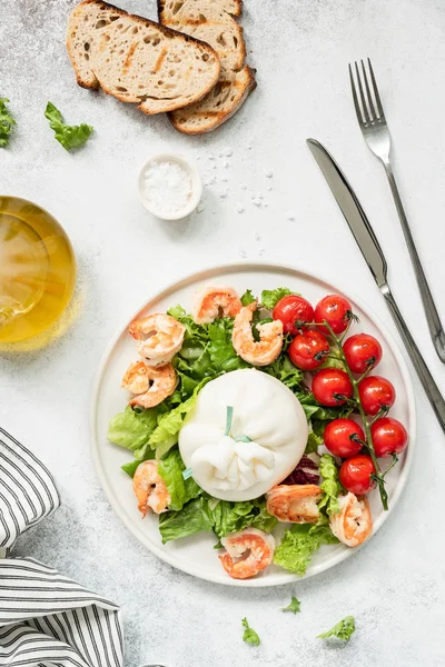 Italienischer Salat mit Garnelen, Salat, Burrata-Käse und Tomaten auf weißem Teller — Stockfoto