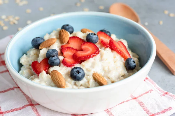 Hot oatmeal porridge with fresh berries and nuts — Stock Photo, Image