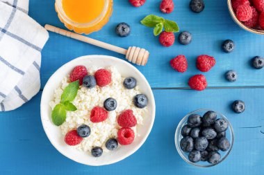 Ricotta taze meyveleri ve ballı mavi masada