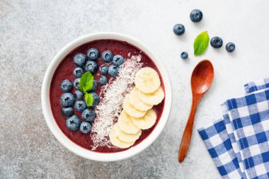 Chia tohum, muz, Hindistan cevizi ve beton zemin üzerine yaban mersini ile superfood acai smoothie kase. Üstten görünüm