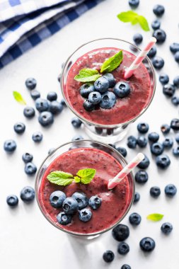 Yaban mersini acai smoothie cam beyaz arka plan üzerinde. Superfood smoothie üstten görünüm. Trendy meyve berry yüzlü