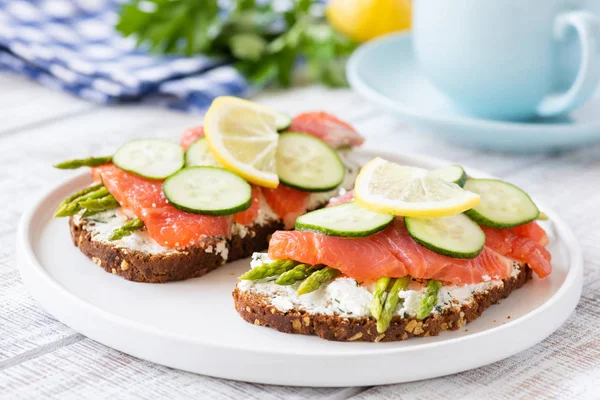 Somon Sandviç ile kuşkonmaz, krem peynir ve salatalık beyaz tabakta. Sağlıklı kahvaltı veya sağlıklı snack. Seçici odak