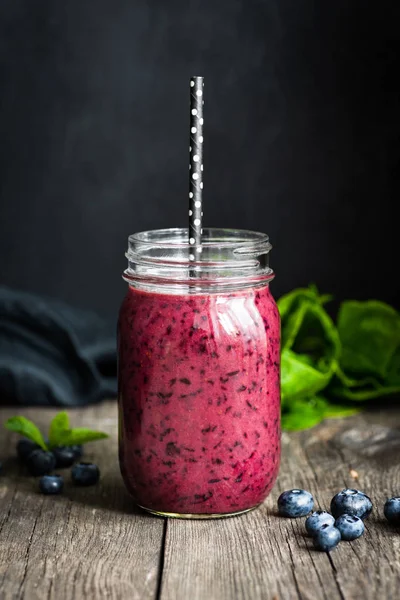Taze acai blueberry smoothie şişe siyah arka plan üzerinde ahşap masa üzerinde. Seçici odak, closeup görüntüleyin. Sağlıklı yaşam, sağlıklı beslenme, diyet, pişmemiş yiyecek ve vegan gıda kavramı