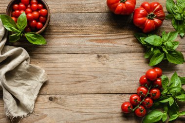 Domates, fesleğen ve tekstil ahşap zemin, yemek yemek üzerine. Rustik gıda arka plan kopya alanı ile. Gıda çerçeve