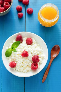 Taze ricotta ya da Lor peynir ahududu ve ballı mavi ahşap arka plan, üstten görünüm üzerinde. Yeme, kavram diyet sağlıklı