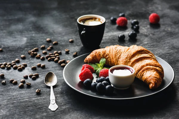 Jahody čerstvé croissanty a šálek kávy — Stock fotografie