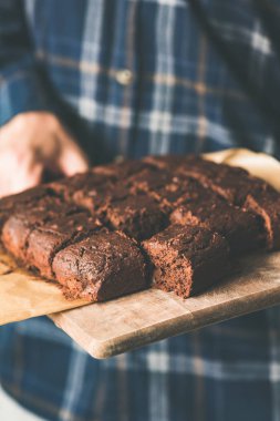 Vegan çikolatalı kek tarihleri ve kesme tahtası üzerinde fındık ile