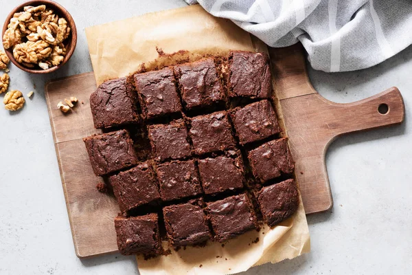 Schokoladen-Brownie-Quadrate auf Schneidebrett, Draufsicht — Stockfoto