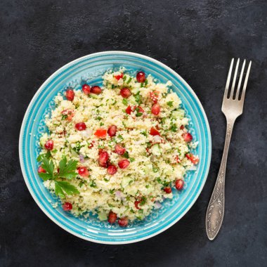Mavi plaka siyah taş kuskus ve nar tohumları ile Tabbouleh salata. Üstten görünüm, kare kırpma