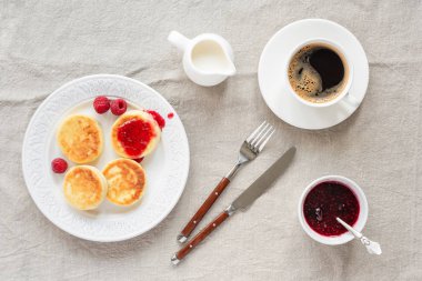 Süzme peynir frambuaz reçeli ve kahve ile krep. Üstten görünüm. Syrniki veya sirniki, Rus yemekleri çiftçiler Peynirli börek veya krep