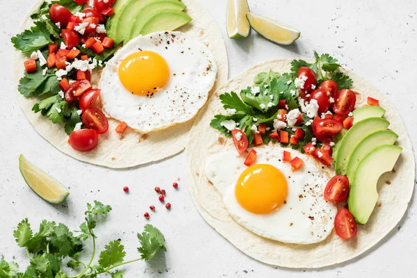 Flatbread tortilla with avocado, salsa and egg on concrete background. Healthy breakfast, lunch or dinner