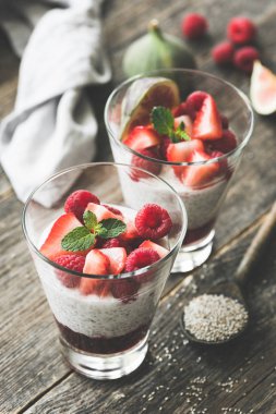 Chia puding cam ahşap masa üzerinde kırmızı çilek ile