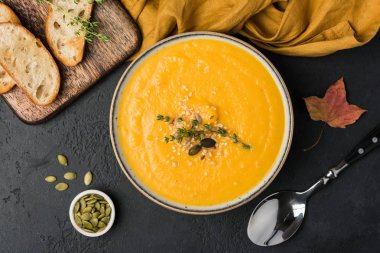 Siyah arka plan üzerine kabak kremalı çorba kasesi