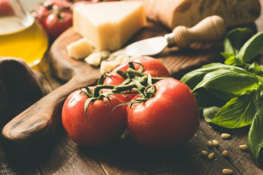 Domates asma, parmesan peyniri, zeytin yağı, fesleğen ve ciabatta ekmeği. İtalyan mutfağı gıda katkı maddeleri. Closeup görünümü, tonlu görüntü