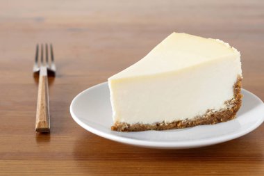 Ahşap masa üzerinde düz New York Cheesecake dilim. Yatay kompozisyon