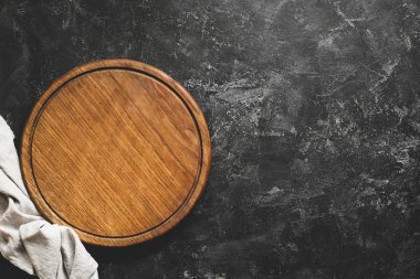 Ahşap kesme tahtası veya siyah beton zemin üzerine pizza yönetim kurulu. Tablo en iyi görünüm ve kopya metin için yer. Restoran menü, yemek tarifi, yemek arka plan kadar sahte